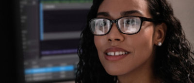 A woman wearing glasses and smiling.