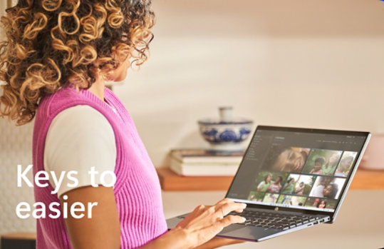 Woman holding her PC with personal pictures on the screen 