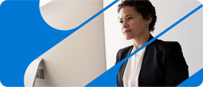 Một người phụ nữ mặc vest đứng trước máy tính