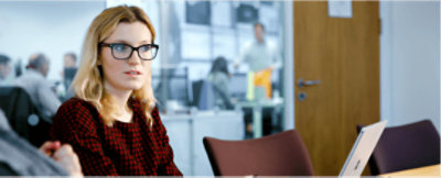 A person working at a tablet with a laptop