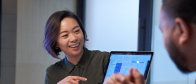 صورة لسيدة تشير إلى كمبيوتر محمول.