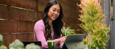 Žena, která sedí u stolu s přenosným počítačem