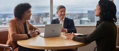 Traja odborníci sedia pri stole a rozprávajú sa.