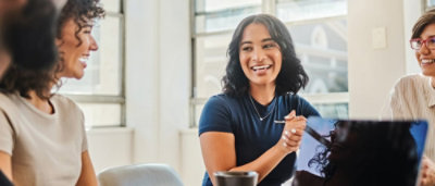A woman smiling while holding a spoon.