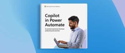 "Copilot in Power Automate" と書かれた白いサインとノートパソコンを持つ青いシャツを着た男性。