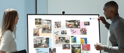 A man and a woman discussing by looking at a screen.