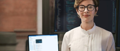 A woman wearing glasses and smiling.