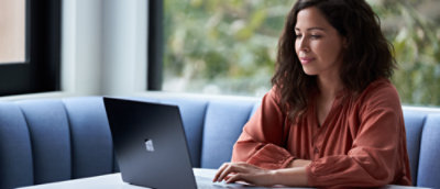 A girl sitting on a couch using a computer