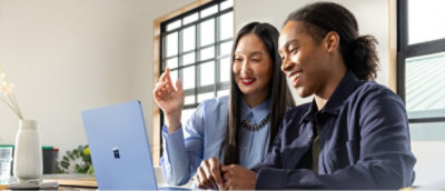 A man and woman looking at a laptop.