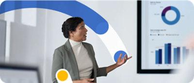 Một người phụ nữ mặc vest đang chỉ tay về phía màn hình lớn