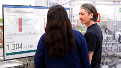 A two person standing in front of a monitor