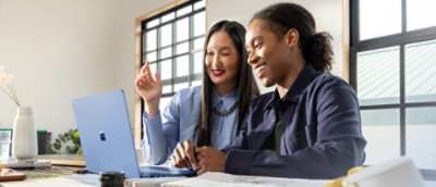 A man and woman looking at a laptop.