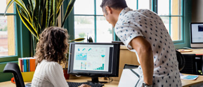 A man and woman looking at a computer screen.