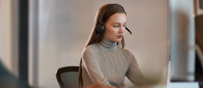 A woman wearing a headset in an office.