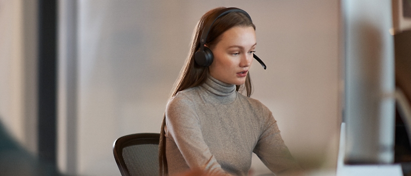 Uma mulher usando um headset em um escritório.