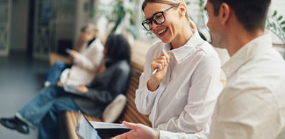 A person smiling while holding a pen