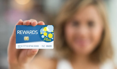 Osoba drži plavu karticu „Rewards Plus“ sa dizajnom žutih i plavih mehurića