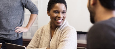 Een vrouw die lacht naar de camera.