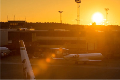 Sunset view of airport with planes at hangar