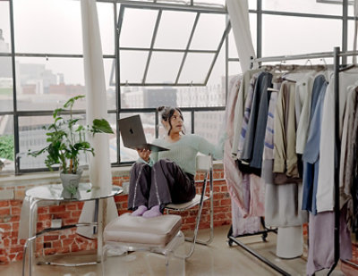 A woman sitting on a chair holding a laptop.