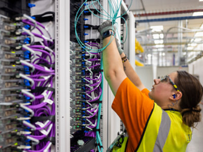 Una mujer trabaja en una estantería de cables