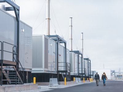 Two people walking in a manufacturing unit on the road.