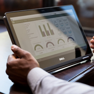 A person holding tablet in his hand and looking dashboard screen