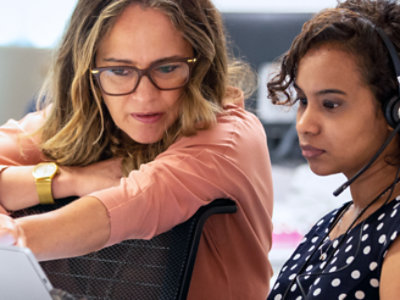 Two women are sitting and looking at the laptop