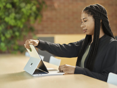A women holding her Microsoft surface pro while sitting on the chair
