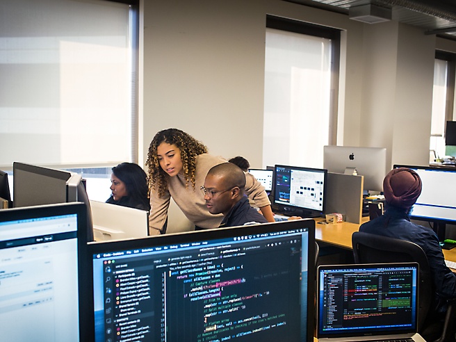 Um grupo de pessoas a trabalhar em computadores num escritório