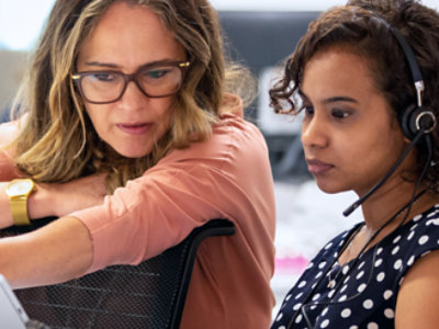 Two women are sitting and looking at the laptop