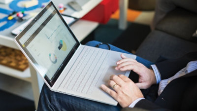 Power BI でデータを表示するノート PC に乗せられた両手