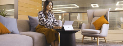 長椅子に座って Surface デバイスを使用している人