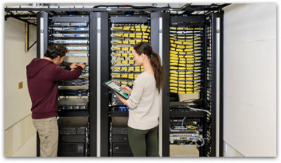 Lidé pracující na počítačích v datovém úložišti