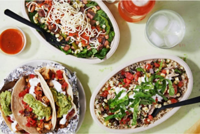 Вид сверху вниз на тако Chipotle и миски с буррито.