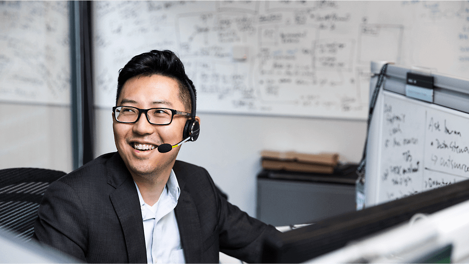 A customer services representative wearing a headset and smiling