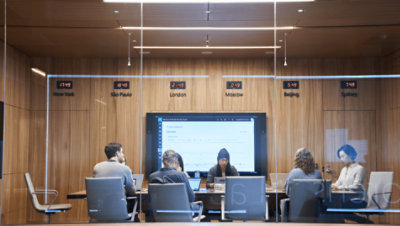 Personen, die eine Besprechung in einem Glaskonferenzraum haben