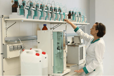 A healthcare professional reaching for a device on a shelf