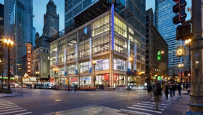 A Walgreens on a busy street corner lit up at dusk