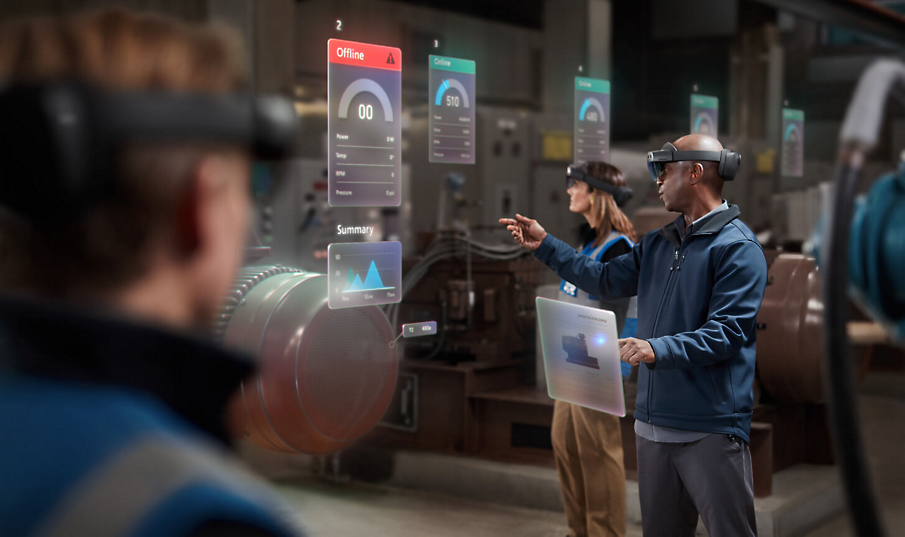 Mitarbeiter*innen in einer Fabrik, die HoloLens-Geräte tragen und gemeinsam Daten betrachten