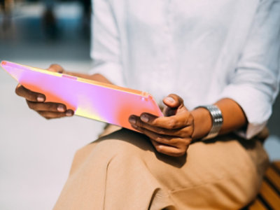 Lähikuva kädestä, joka pitelee vaaleanpunaista tablettia.