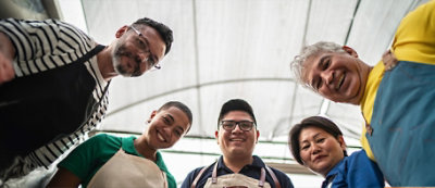 חמישה אנשים לובשים סנרים ועומדים בחצי מעגל, מחייכים ומביטים מטה לעבר המצלמה