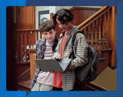 Two students working on a laptop
