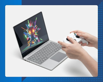 A person with a joystick in his hands and working on a laptop