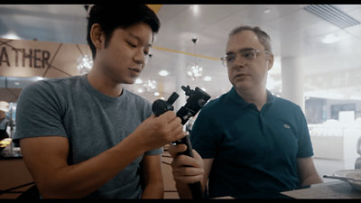 長いアームのような仕掛けを作りながら会話する 2 人。