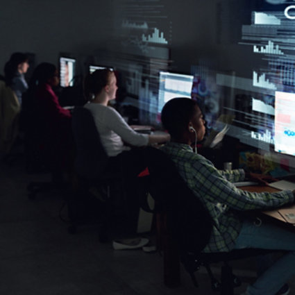 Young adults working on laptops in a cybersecurity atmosphere