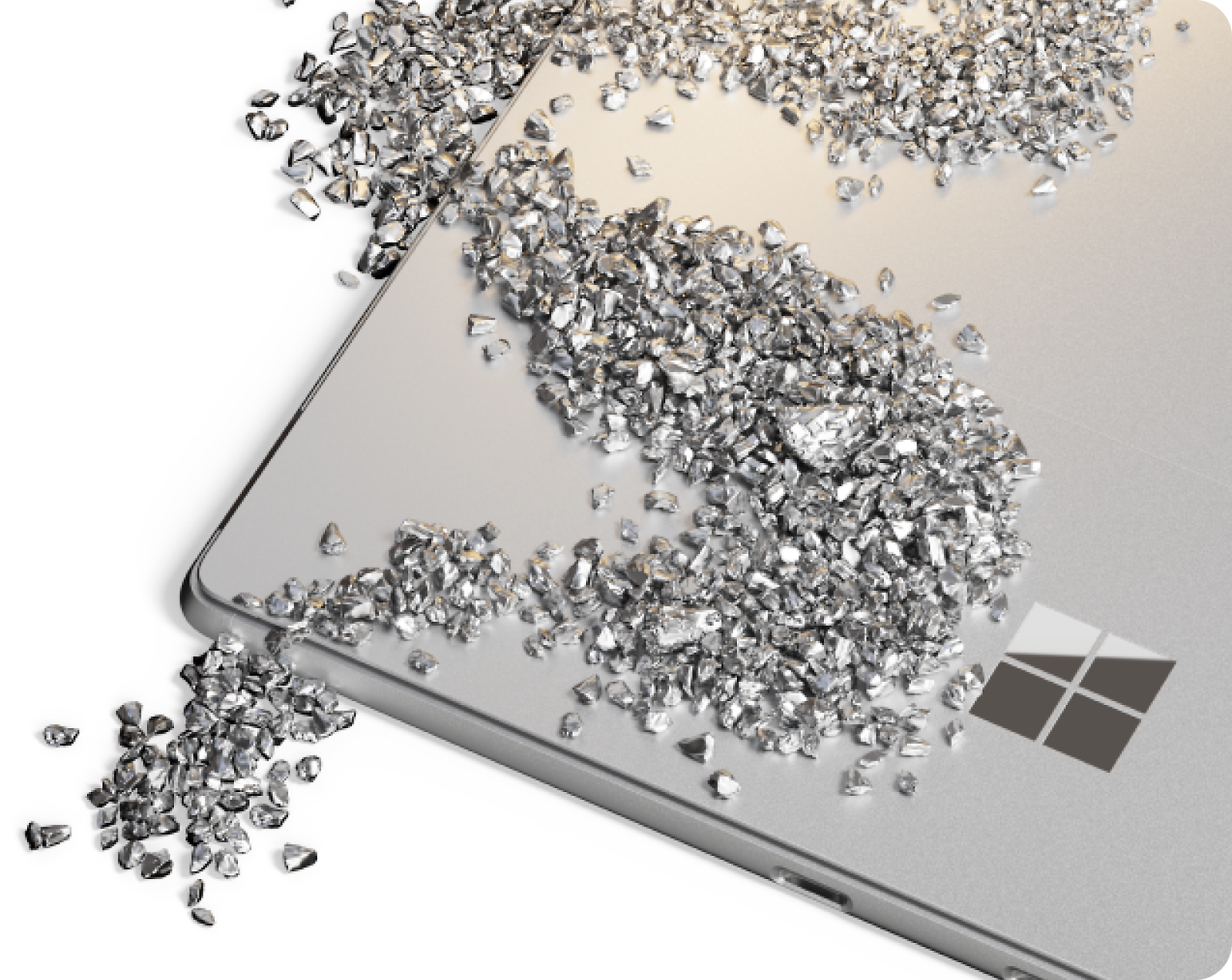 A close-up image of a silver laptop with a Microsoft logo, covered in and surrounded by small scattered pieces of reflective metal