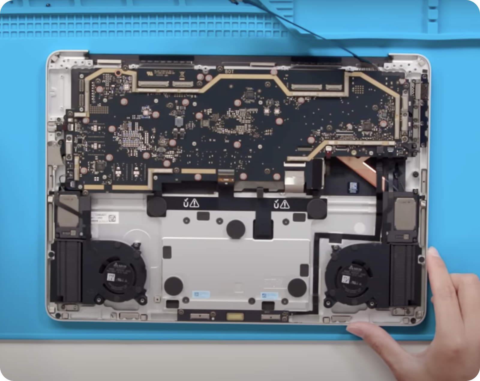 An open laptop with the cover removed, revealing its internal components including the motherboard, cooling fans