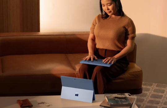 Une personne assise utilisant une Surface Pro couleur Saphir avec le clavier détaché.