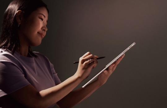 Een persoon schrijft met een pen op een Platina Surface Pro.